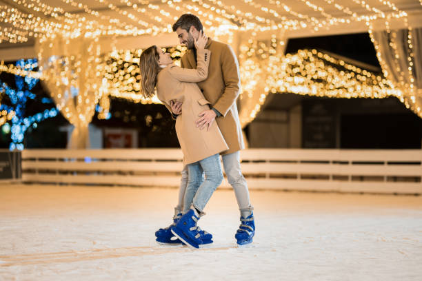 istock Happy couple having fun ice skating. 1905926619