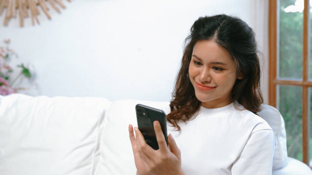istock Young woman using smartphone browsing for online shopping E commerce by online payment gateway at vivancy home. Modern and convenience online purchasing make secure and convenient purchases. 1905926629