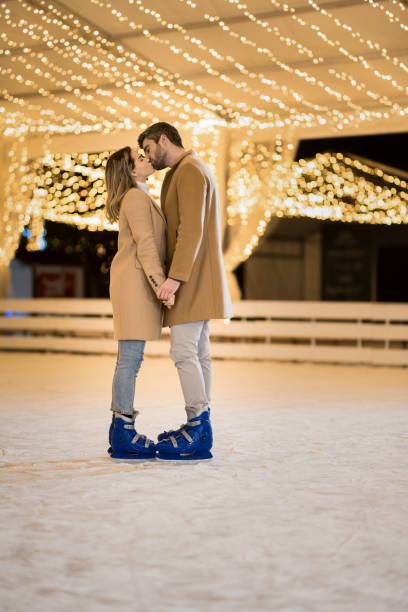 istock Young couple kissing while ice skating on a winter holiday. 1905928912