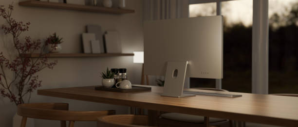 istock A modern, cosy office workspace in the evening with a computer on a wooden table. 1905979755