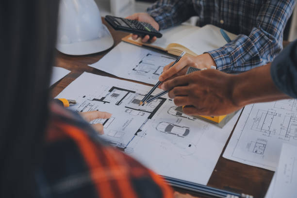 istock A team of construction engineers talks to managers and construction workers at the construction site. Quality inspection, work plan, home and industrial building design project 1906036822