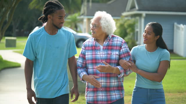 Young adults spending time with senior man, taking walk