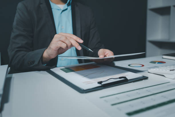 istock using computer together in office, successful business people working together in a co-working office, two business professionals working on a tech project, business colleagues talking to each other, 1906070044