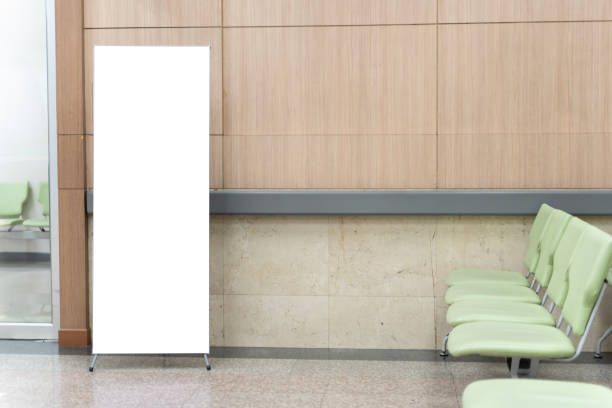 istock Blank roll up stand banner. Blank mockup for presentation, clipping path. A row of chairs is lined up against a wall in a waiting room. 1906089447