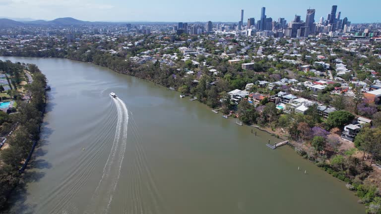 Ferry Boat Sailing Away From Terminal Near Green Bridge On Brisbane River In Queensland, Australia. aerial shot