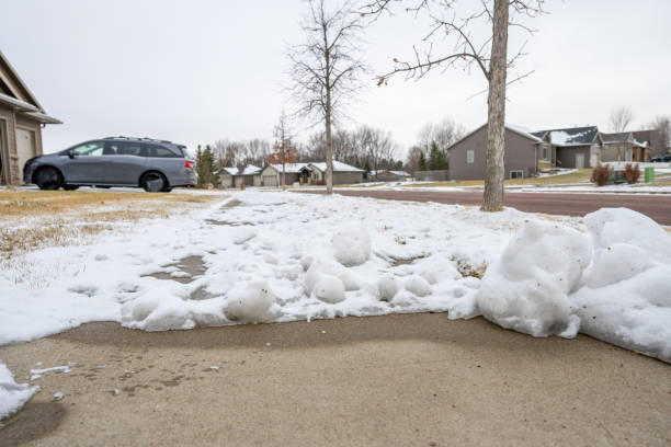 istock Residential sidewalk with section that has been cleared of snow next to a covered path. 1906130579