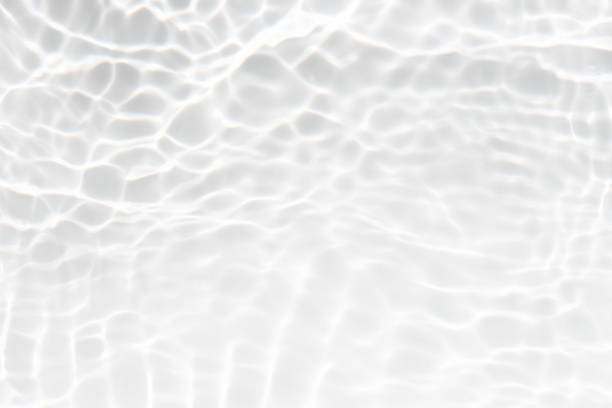 istock White water with ripples on the surface. Defocus blurred transparent white colored clear calm water surface texture with splashes and bubbles. Water waves with shining pattern texture background. 1906140421
