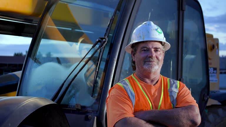 Worker standing in front of construction vehicle