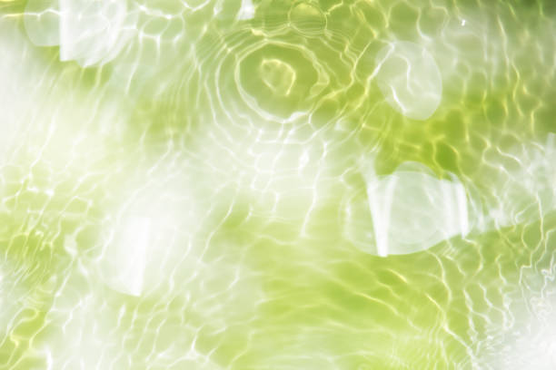 Bluewater waves on the surface ripples blurred. Defocus blurred transparent blue colored clear calm water surface texture with splash and bubbles. Water waves with shining pattern texture background.