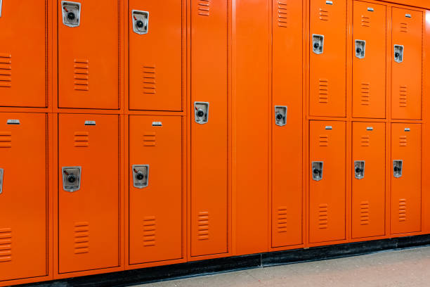 istock Orange metal lockers along a nondescript hallway in a typical US High School.  No identifiable information included and nobody in the hall. 1906152248