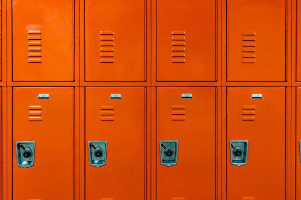 istock Orange metal lockers along a nondescript hallway in a typical US High School.  No identifiable information included and nobody in the hall. 1906152818