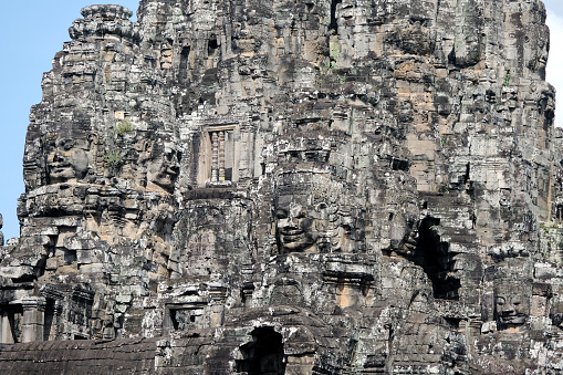 Majestic Bayon, a richly decorated Khmer temple at Angkor in Cambodia. Built in the late 12th or early 13th century as the state temple of the King Jayavarman VII, the Bayon stands at the centre of Jayavarman's capital, Angkor Thom.\nThe Bayon's most distinctive feature is the multitude of serene and smiling stone faces of The Buddha.