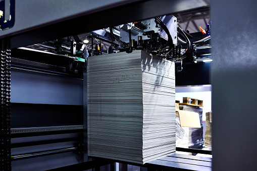 Close-up of the paper feeding at printing press.
