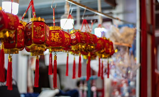 Red lanterns hanging during Chinese New Year with blessing and good luck written in Chinese