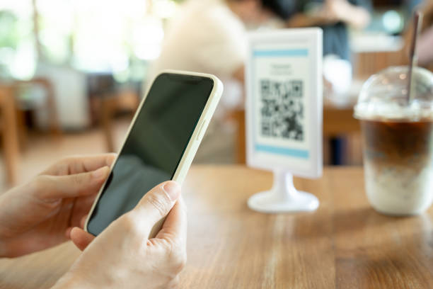 istock Woman use smartphone to scan QR code for order menu in cafe restaurant with a digital delivery. Choose menu and order accumulate discount. E wallet, technology, pay online, credit card, bank app. 1906256627