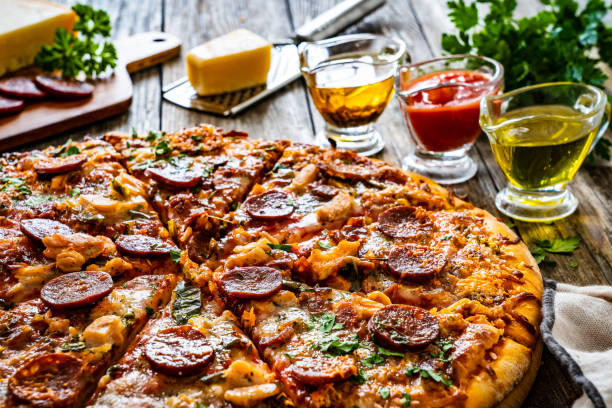 istock Circle pizza chorizo with chicken nuggets and mozzarella, on wooden table 1906260274