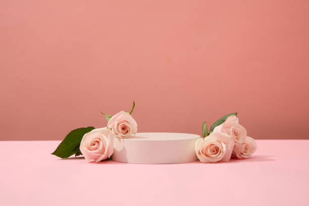 istock Roses are decorated around a podium on a pink background. Ideal space for cosmetics display. Beauty theme for advertising. Copy space with front view. 1906289856