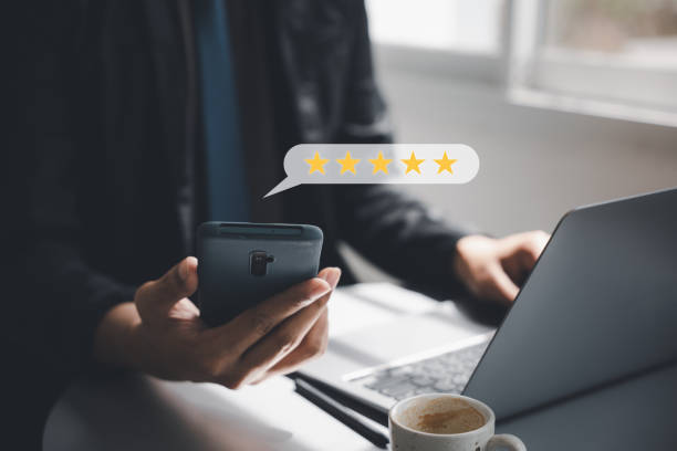 Man using smartphone and laptop computer to rate and evaluate services