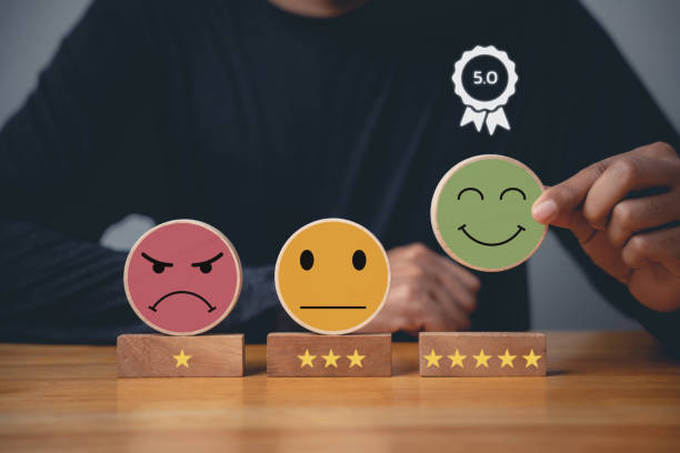 istock Selecting a smiley face on a wooden block circle 1906316439