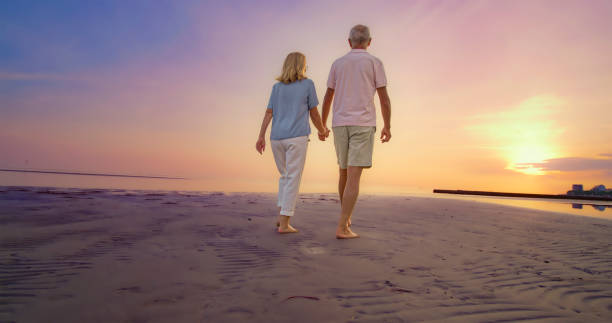 istock Senior couple walking on beach 1906326018