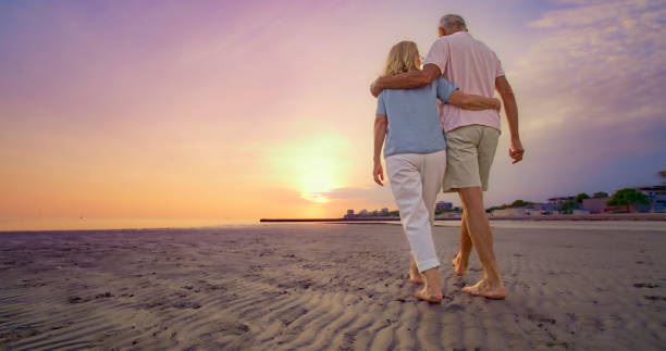 istock Senior couple walking on beach 1906326031
