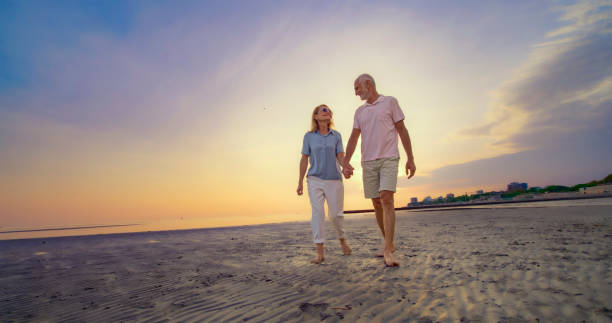 istock Senior couple walking on beach 1906326032