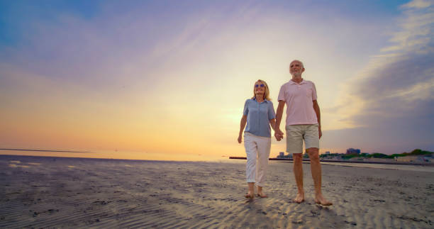 istock Senior couple walking on beach 1906326040