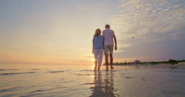 istock Senior couple walking on beach 1906326048