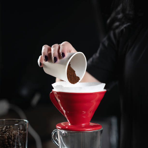 istock Female Barista Pours Grounded Coffee into Ceramic Coffee Dripper 1906407789
