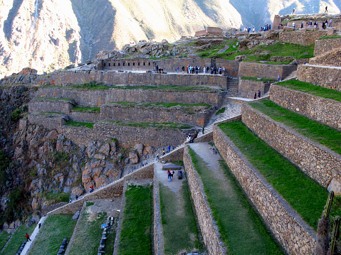 Mid-shot front view of young Latin woman enjoying the view while standing on footpath in Sacred City of Machu Picchu, Peru
