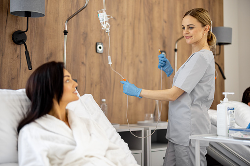 Nurse with blue gloves adjusting IV