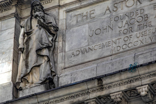 ein denkmal und eine statue in manhattan, die die fassade der big apple public library schmücken. - statue apple roman sculpture stock-fotos und bilder