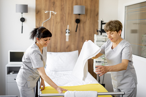 Maids make the bed in medical ward. Concept of comfortable and modern conditions for the medical stay of patients