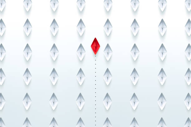 istock Red paper ship pointing in different way among white paper ship on white background. New idea, Unique way and Business for innovative solution concept. 1906496076