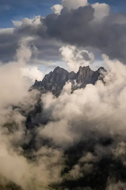 The tall peaks of the Peitlerkofelgruppe in the Dolomites standing above cloud and fog in South Tyrol. The tallest peak is known as the Tullen.