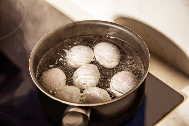 istock eggs are boiling in water in black stewpot close-up 1906562789
