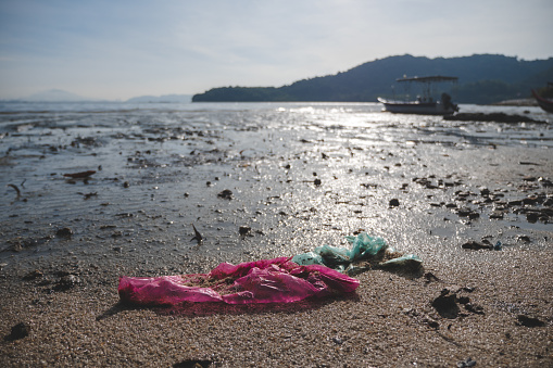 Wide shot of plastic waste washed up at the beach, creating pollution to the environment