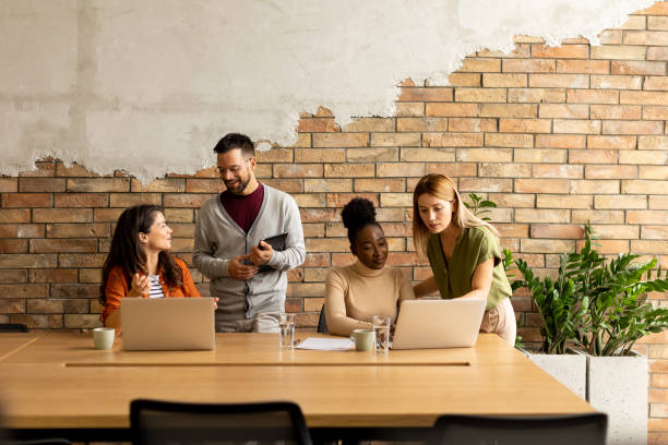 istock Young multiethnic startup team working by the brick wall in the industrial style office 1906577681