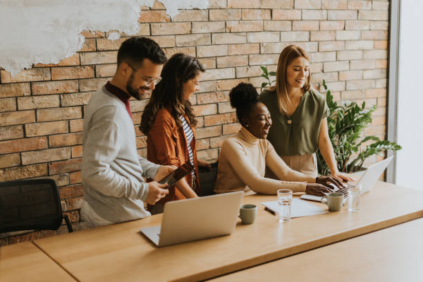 istock Young multiethnic startup team working by the brick wall in the industrial style office 1906577688
