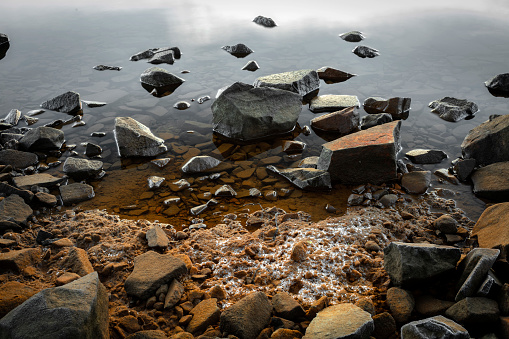 A tranquil beach with rocks, creating a peaceful and calming atmosphere