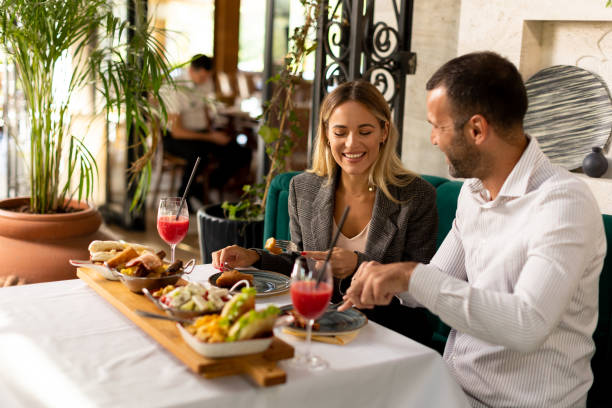 istock Young couple having lunch and drinking fresh squeezed juice in the restaurant 1906580347