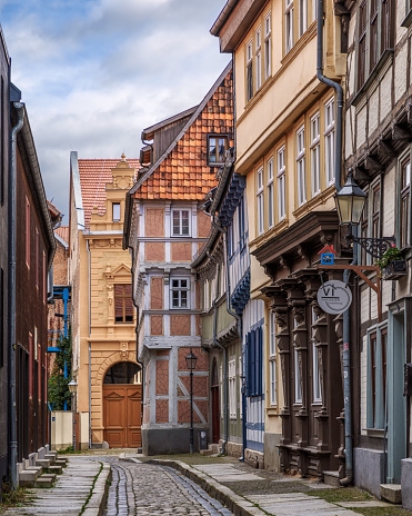 Quedlinburg, Germany – October 31, 2023: A cobblestone street with historic buildings in Quedlinburg, Germany