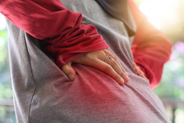 istock mature woman with backache gestures and holds her waist, selective focus. 1906587421