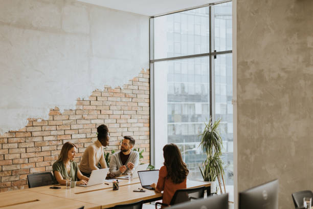 istock Young multiethnic startup team working by the brick wall in the industrial style office 1906614405