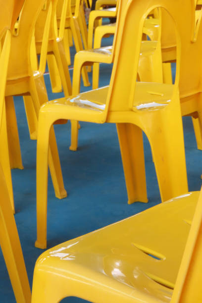 yellow plastic chairs set up in school gymnasium, bangkok, thailand. - school gymnasium plastic furniture event ストックフォトと画像
