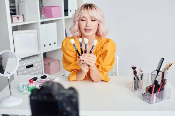 Photo of Woman with cosmetic brushes in hands