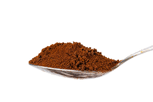 Side view of organic instant coffee powder in metal teaspoon isolated on white background with clipping path.