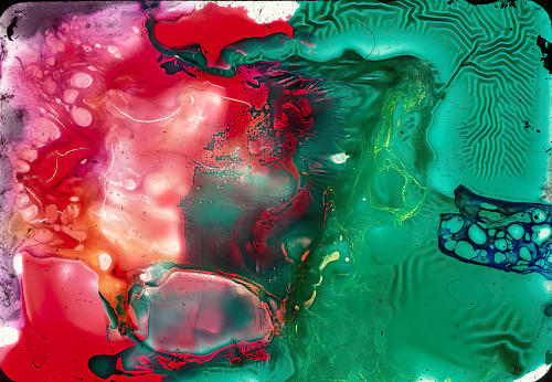 This photograph showcases an abstract composition with vibrant red and green hues intermingling in a dynamic and fluid pattern.