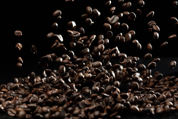 istock Coffee roasted bean fly explosion, Coffee crushed float pouring mix with beans. Roasted Coffee bean splash explosion in mid Air. Black background Isolated selective focus blur 1906649465