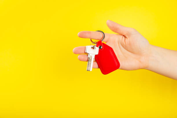istock Leather keychain with a key ring on  background. Concepts for real estate and moving home or renting property. Buying a property. Mock-up keychain.Copy space. 1906691732